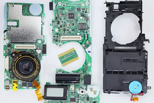 Compact camera taken apart into its lens, circuit boards, screen and frame